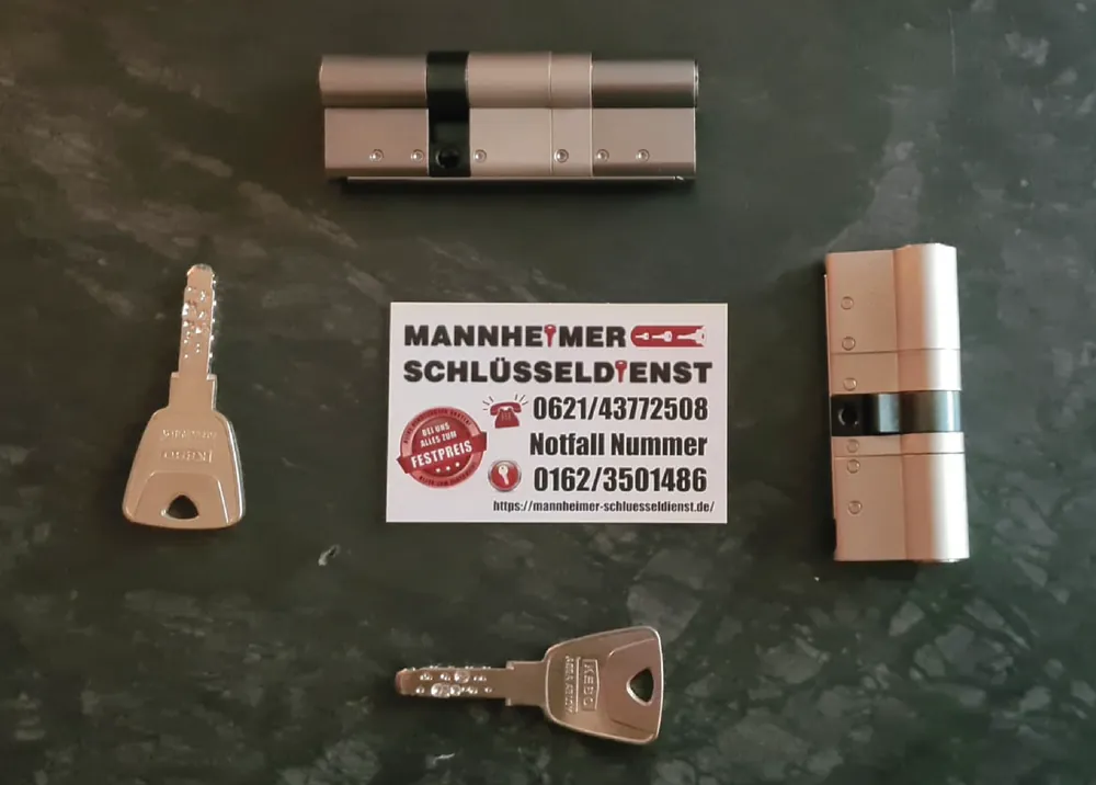 Schließanlage mit KESO 8000 Omega Zwei KESO 8000 Omega Schließzylinder mit Schlüsseln und Visitenkarte des Mannheimer Schlüsseldienstes – gleichschließend bestellbar